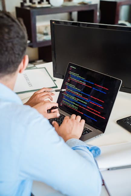 A close-up view of a computer screen displaying multicolored lines of programming code, including keywords, functions, and variable names, with a blurred background to emphasize the digital environmen